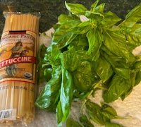 a package of pasta and fresh basil on a table